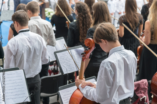 Men with a cello in an orchestra.