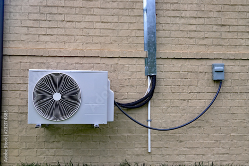 Obraz na płótnie Air Conditioner mini split system next to home with brick wall