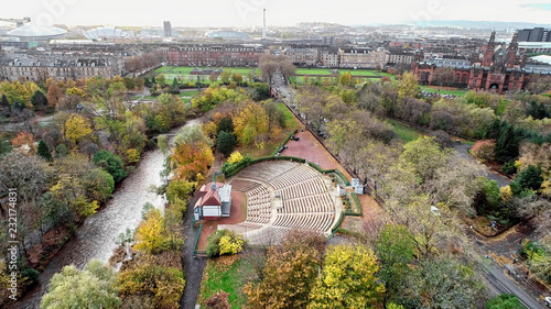 Fotografie Aerial image over the restored open air bandstand and amphitheatre in Kelvingrove Park, Glasgow, surrounded by autumn coloured woodland and the River Kelvin to the Art Gallery and Museum