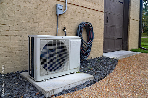 Tapety artystyczne Air Conditioner mini split system next to home with brick wall