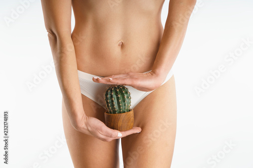 woman holding a cactus on a background of white panties, close-up, depilation of a bikini zone