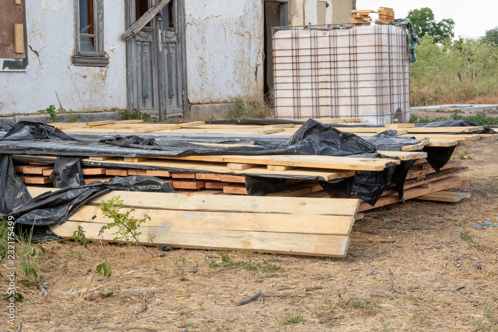 A stack of pine boards soaked in an antiseptic solution is dried at the construction site. Building materials for the construction of a frame house. A stack of pine boards soaked in an antiseptic solution is dried at the construction site. Building materials for the construction of a frame house.