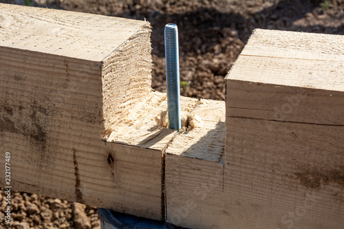 Anchor bolt for connecting pine planks of the frame house. Construction stages of the A-type frame house