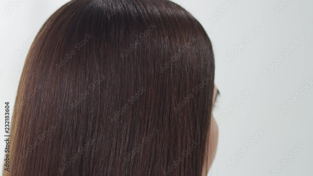Camera slowly pans and tilts through very long brown hair. Slow motion. Camera slowly pans and tilts through very long brown hair. Slow motion.