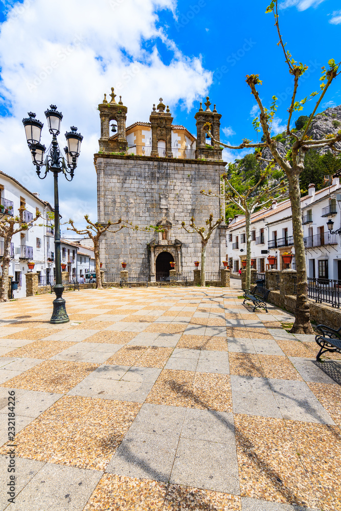Church facade and white houses in Grazalema mountain village, Andalusia, Spain