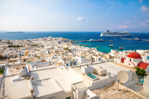 Panoramic view over Mykonos town with white architecture and cruise liner in port, Greece