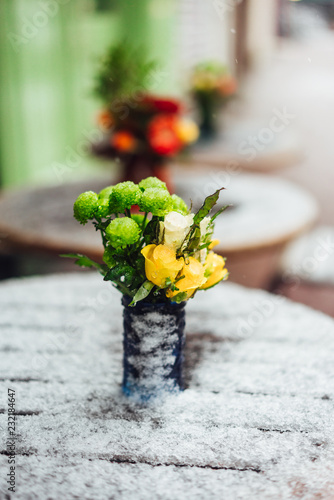 Flowers stand on a snowy table photo