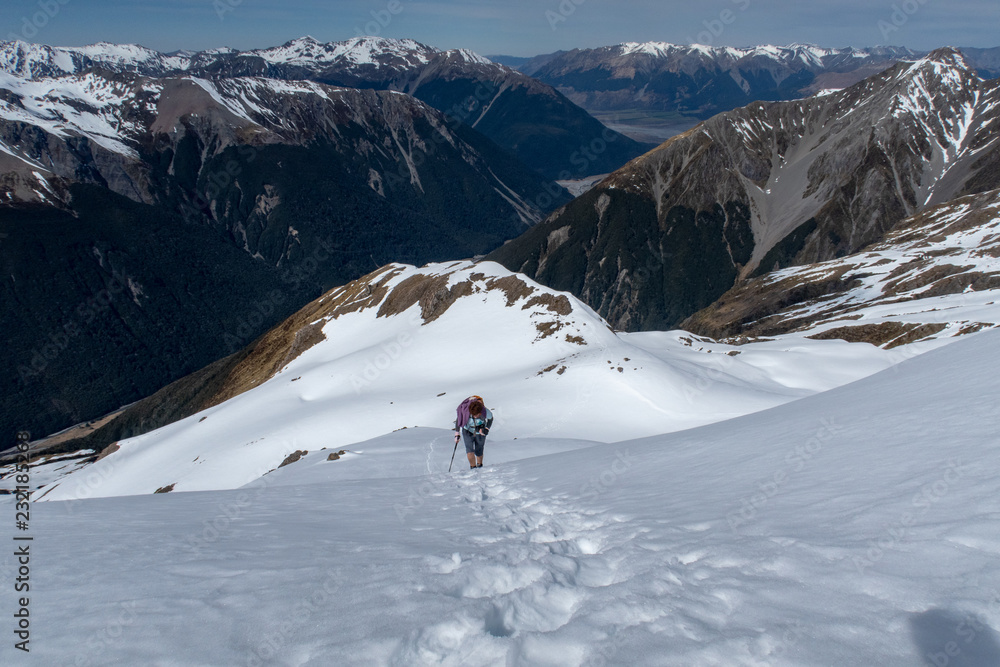 A woman, who lives a healthy lifestyle, descends the mountain after reaching the peak of a mountain range in New Zealand