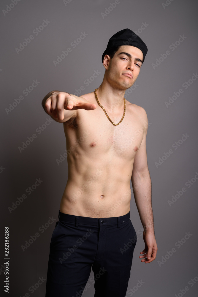 Young handsome man shirtless against gray background