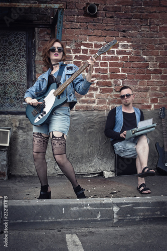 Girl and guy punks play on guitars