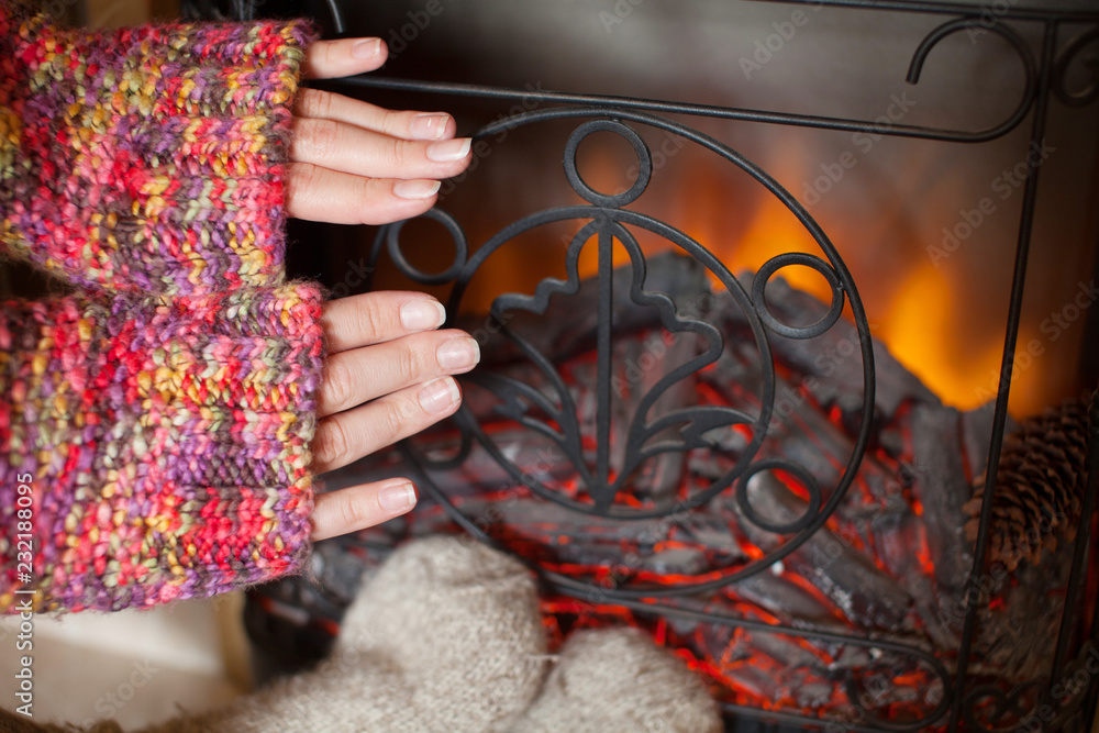 Feet and hands in wool socks warming by cozy fire Feet and hands in wool socks warming by cozy fire