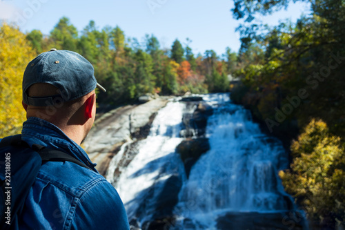 Hiker enjoying the beauty of High Falls in Dupont State Forest in the fall.