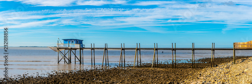 Fotografie vue panoramique sur une cabane bleue au bout d'un ponton sur pilotis
