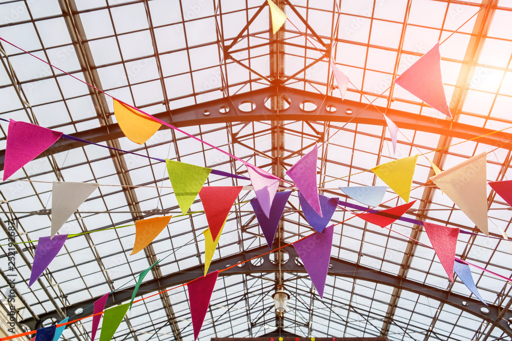 Fototapeta premium Many colorful flags under the openwork metal ceiling. close-up view. concept of holiday mood