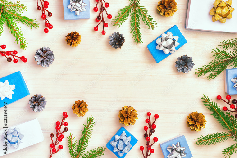 Obraz premium Christmas composition, frame in a circle of fir branches, gift boxes and gold and silver cones. In the center is an empty space for text, Copy Space.