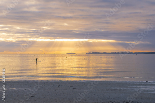 Landscape Scenery of Takapuna Beach Auckland  New Zealand  Sunrise time some people are enjoying paddle-boarding 