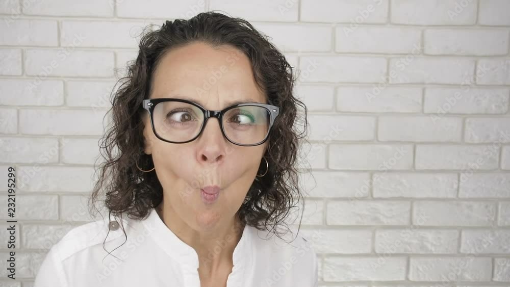 Girl making faces. Woman in glasses grimaces Girl making faces. Woman in glasses grimaces