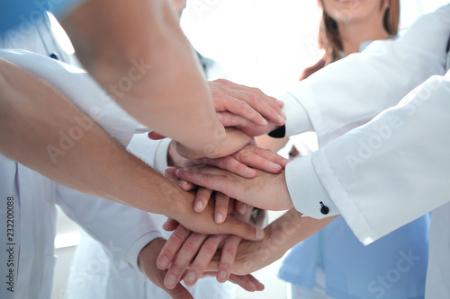 group of doctors with their hands folded together