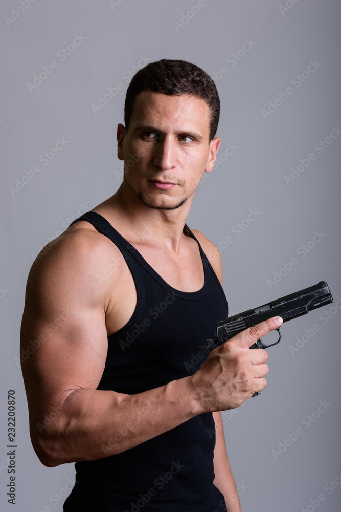 Studio shot of young muscular Persian man thinking while holding Studio shot of young muscular Persian man thinking while holding