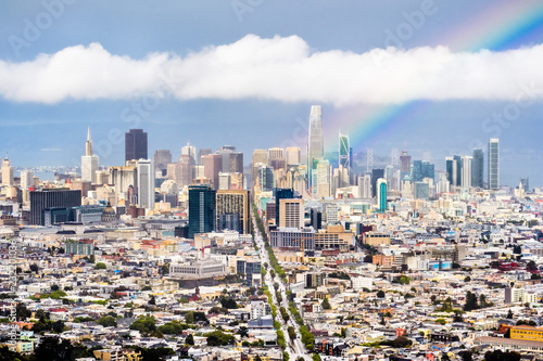 Aerial view of San Francisco's financial district skyline on a rainy day, bright rainbow rising from downtown; April 2018