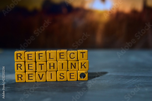 Reflect - Rethink - Revise on wooden blocks. Cross processed image with bokeh background photo