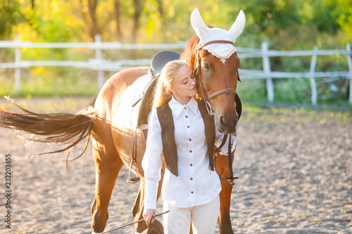 Girl equestrian rider riding a beautiful horse in the rays of the setting sun. Horse theme