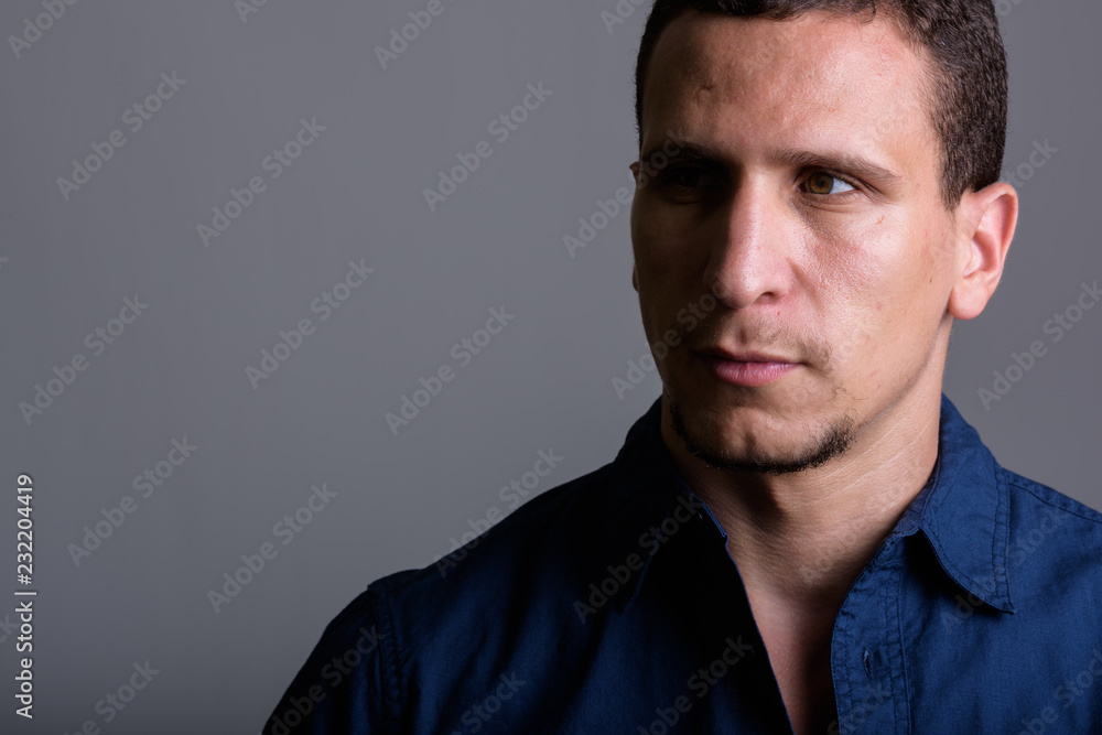 Close up of young muscular Persian man thinking and looking at d Close up of young muscular Persian man thinking and looking at d