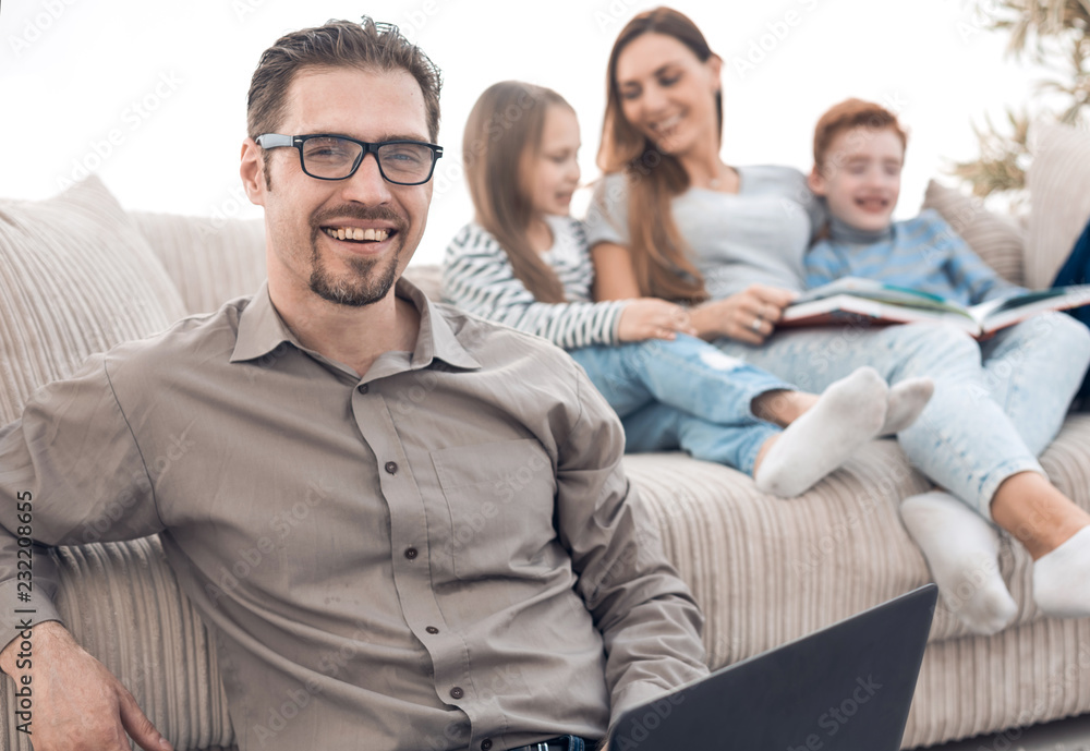 smiling man with a laptop in his apartment. smiling man with a laptop in his apartment.