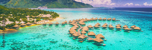 Travel vacation Tahiti hotel ocean beach paradise of overwater bungalows resort in coral reef lagoon ocean. View from above at sunset of Moorea, French Polynesia, Tahiti, South Pacific Ocean.