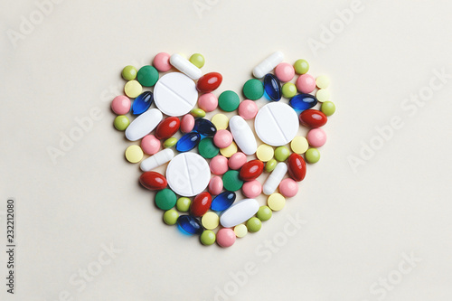heart made of assorted multi-colored pills, capsules and tablets, heart disease treatment, top view, flat lay