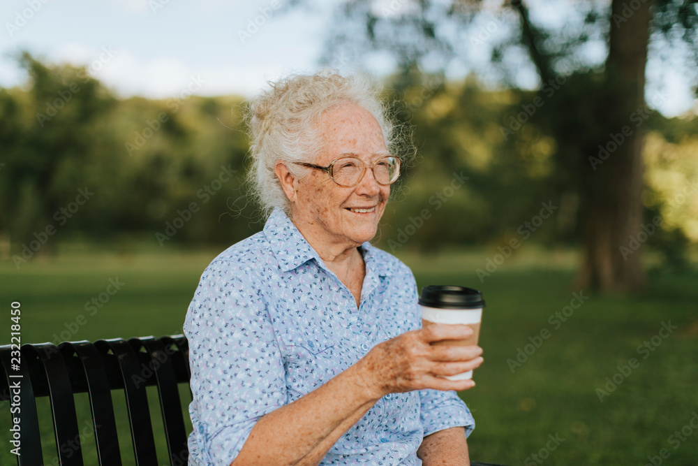 Happy senior woman having a takeaway coffee at the park Happy senior woman having a takeaway coffee at the park