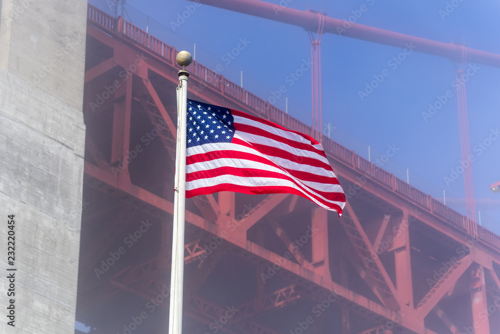 american flag in front of blue sky  and  Golden Gate Bridge in the background 