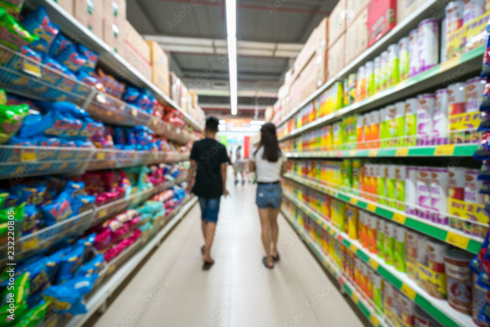 Supermarket blurred background with colorful shelves and unrecognizable customers