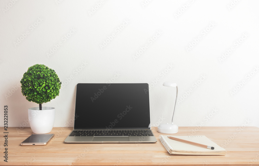 Artificial tree with notebook laptop mobile phone and pencil on work desk. Artificial tree with notebook laptop mobile phone and pencil on work desk.
