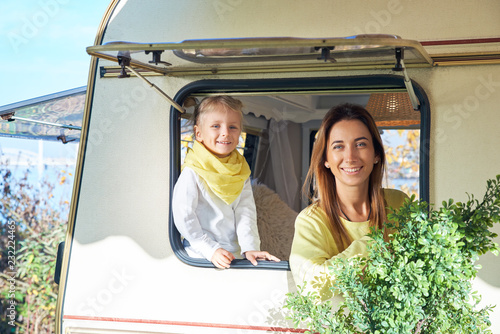Motor mobile home. The family travels around the countries. The girl and mother look out of the window and smile friendly photo