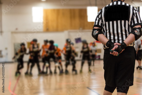 Fotografia Roller derby referee watches teams for penalties