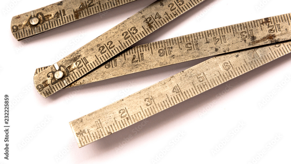 Old metal rusty folding ruler as used by carpenter. Isolated on white Old metal rusty folding ruler as used by carpenter. Isolated on white