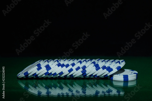 Casino games concept,Poker chips on gamble table , Light through background, winning hands of cards. gambling success