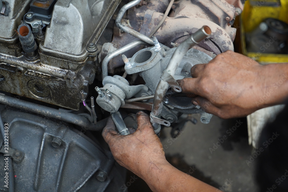 Hand working on car's engine Hand working on car's engine