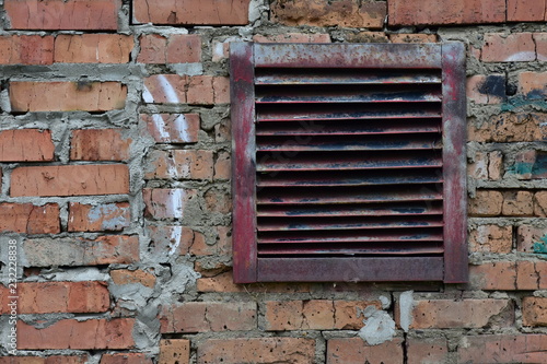 metal ventilation grille in red brick wall. original background