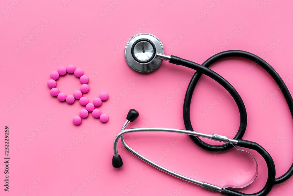 Female diseases concept. Stethoscope near female sign on pink background top view Female diseases concept. Stethoscope near female sign on pink background top view