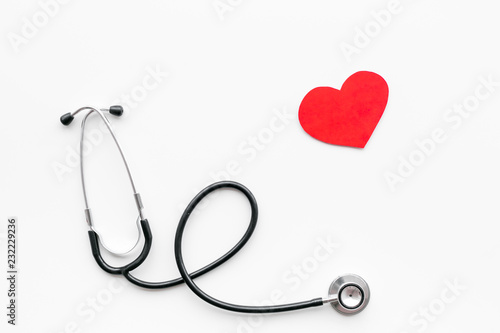 Heart disease concept. Stethoscope near heart sign on white background top view