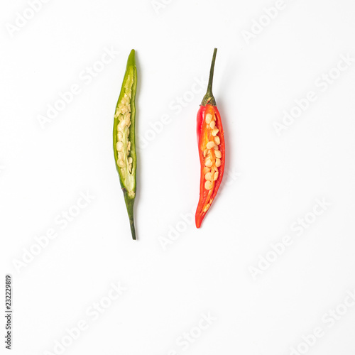 Cut half green and red hot chilli pepper on white background. Copy space for text. Top view or flat lay. Two half peppers isolated on white with clipping path.