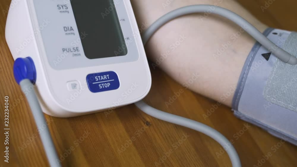 A man measures his blood pressure with a tonometer at home. Close-up view of the tonometer display and the hand of a man A man measures his blood pressure with a tonometer at home. Close-up view of the tonometer display and the hand of a man
