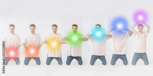 Man meditating. Colored chakra lights over his body. Yoga, zen, Buddhism, recovery and wellbeing concept.
