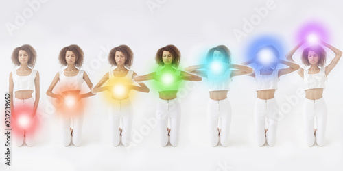 Woman meditating. Colored chakra lights over her body. Yoga, zen, Buddhism, recovery and wellbeing concept.