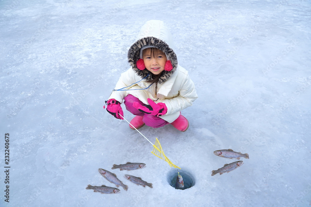 Cute girls are sitting on the floor of ice fishing. Ice Fishing Tournament. Ice  Fishing Travel at the North Pole. Ice Fishing Tour at Antarctica. Stock  Photo