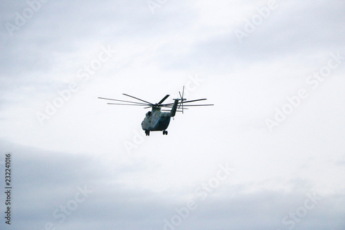 Fototapeta Naklejka Na Ścianę i Meble -  a large military helicopter hovers in the sky. A camouflaged helicopter flies at high speed.