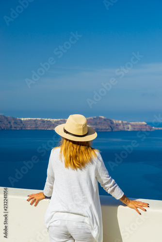 Luxury travel vacation woman looking at view on Santorini island © Netfalls