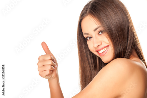 Portrait of young beautiful woman with makeup on white background and showing thumbs up